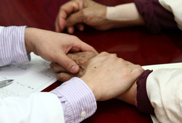 잠실자생한방병원 자생치료의 특징-환자 손을 잡아 건강상태를 체크 하고 있는 의사의 모습